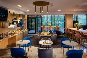 a restaurant with tables and chairs and a bar at Rosslyn Thracia Hotel Sofia in Sofia