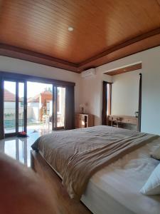 a bedroom with a large bed with a wooden ceiling at Ubud nadi villa in Tegalalang +42 photos