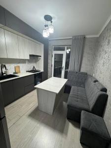 a kitchen and living room with a couch and a table at Bahor Yunusabad Lux in Tashkent
