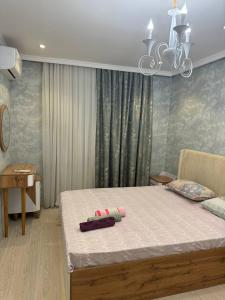 a bedroom with a bed and a chandelier at Bahor Yunusabad Lux in Tashkent