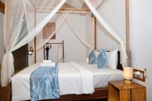 a bedroom with a bed with white sheets and blue pillows at Habana Angkor Boutique Hotel in Siem Reap +29 photos
