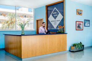 a man talking on a cell phone at a reception desk at 4R Meridià Mar in Hospitalet de l'Infant