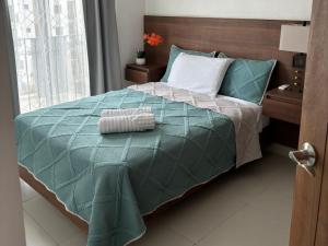 a bedroom with a bed with a green comforter at Aztec Penthouse in Ensenada +12 photos