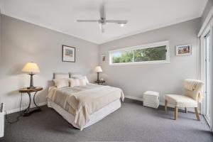 Un dormitorio blanco con una cama y una ventana. en Live the Luxury lifestyle in Lohr, en Inverloch