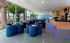 un restaurante con asientos azules en un edificio en 4R Meridià Mar, en Hospitalet de l'Infant