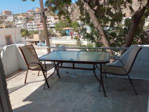 a table and two chairs sitting on a balcony at Carob Tree apartment, Tris Ekklisies in Paránimfoi