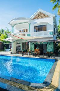 a villa with a swimming pool in front of a house at Habana Angkor Boutique Hotel in Siem Reap
