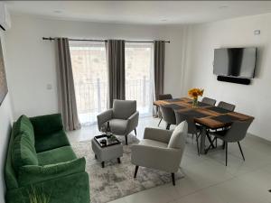 a living room with a dining room table and chairs at Aztec Penthouse in Ensenada
