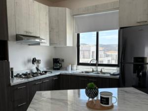 a kitchen with a counter top and a large window at Aztec Penthouse in Ensenada