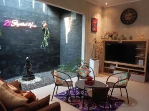 a living room with a couch and chairs and a tv at 24StaycationHome in Yogyakarta