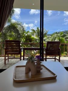 a table with a tray with a vase of flowers on it at Sawasdee Home Stay Resort & Pool in Khao Lak