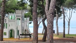 a castle like building in a park with trees at small miramare appartamento sogno sul mare in Trieste