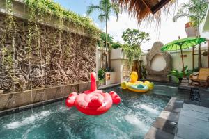 a swimming pool with some inflatable ducks in the water at The Umane Luxury Balinese Private Pool Villa in Melaka