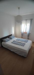 een slaapkamer met een groot wit bed met twee ramen bij Posolica in Ražanac