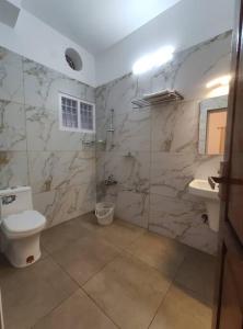 a bathroom with a toilet and a sink at Riveria Portico - River side 6 bedroom private pool Bungalow in Parūr