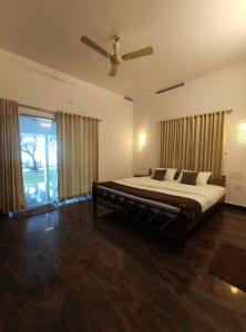 a bedroom with a bed and a ceiling fan at Riveria Portico - River side 6 bedroom private pool Bungalow in Parūr +13 photos