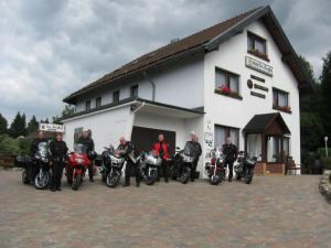un grupo de motocicletas estacionadas frente a un edificio en Pension - Der Berghof, en Braunlage