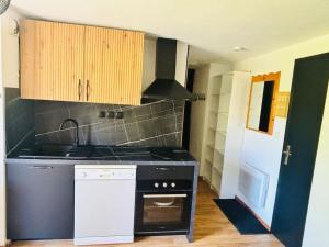 a kitchen with a stove and a stove top oven at La Parenthèse Chamroussienne - Proche pistes de ski in Chamrousse