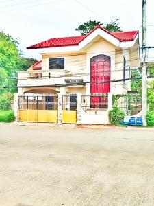 a house with a red door and a fence at Mactan Cebu Home in Lapu Lapu City