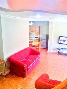 a red couch in a living room with a kitchen at Mactan Cebu Home in Lapu Lapu City