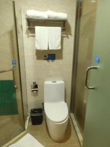 a bathroom with a toilet and a shower and towels at 海岸秀月楼酒店 in Shenzhen