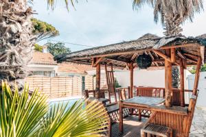 einen hölzernen Pavillon mit einer Bank und einem Tisch in der Unterkunft Rêve D'azur plage de la Nartelle, Mazet 35m2, parking, Piscine partagée, Terrasse BBQ & draps inclus in Sainte-Maxime