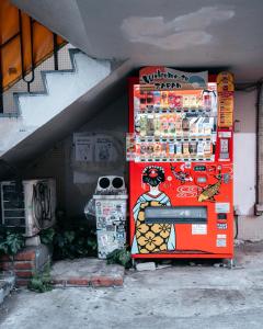 a red refrigerator with a painting on the side of it at illi Com Shimokitazawa in Tokyo