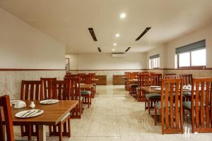 OttappālamSahya Regency的配有木桌椅的餐厅