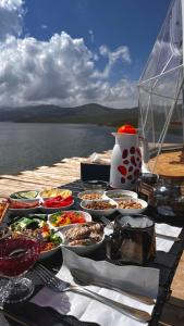 a table with plates of food on top of the water at Son-Köl Glamping in Song-Kul