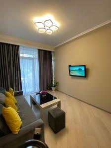a living room with a couch and a flat screen tv at Tsaghkadzor Alvina Complex 12 Project in Tsaghkadzor
