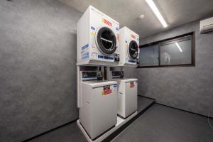 a laundry room with two washing machines and a window at RESI STAY Yasaka in Kyoto