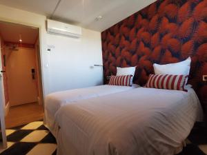 ein Schlafzimmer mit einem großen Bett und zwei Kissen in der Unterkunft Hôtel Le Mercator in Vendôme