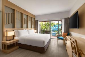 a hotel room with a bed and a balcony at Courtyard by Marriott Phuket, Patong Beach Resort in Patong Beach