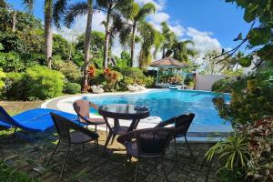 a table and chairs next to a swimming pool at Villa Celine Laguna in Masaya