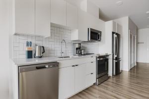 a kitchen with white cabinets and stainless steel appliances at Blueground Revere spa gym pool wd lounge BOS-1100 in Boston