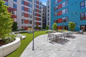 a courtyard with tables and chairs and buildings at Blueground Revere spa gym pool wd lounge BOS-1100 in Boston