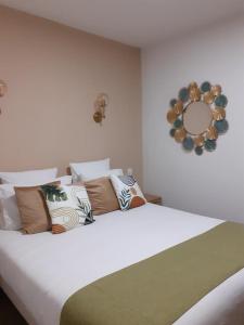 a bedroom with a large bed with pillows and a mirror at Golf Resort de Digne-les-bains by Adonis in Digne-les-Bains