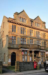 ein altes Backsteingebäude an der Ecke einer Straße in der Unterkunft The Rafters Bank House Stunning Apartment in Millom