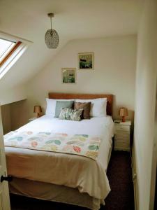 ein Schlafzimmer mit einem Bett und zwei Lampen und einem Fenster in der Unterkunft The Rafters Bank House Stunning Apartment in Millom