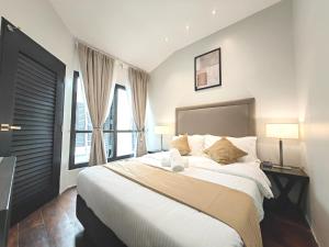a bedroom with a large bed and two windows at Cozy Home 3BR 8pax The Prive Malacca Jonker Street in Melaka