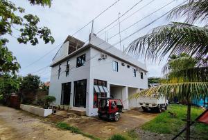 a white house with a tractor parked in front of it at RedDoorz at Elton Guesthouse in Numancia