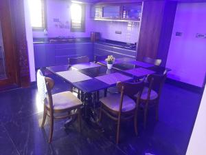 a dining room with a purple table and chairs at The Grassland homestay in Chikmagalūr
