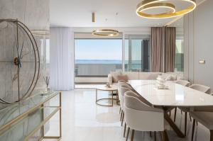 a living room with a white table and chairs at Penthouse La Vie with seaview and jacuzzi in Podstrana