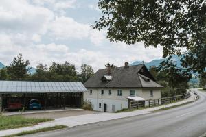 a white house with a barn next to a road at NaturparkResort Almmauer in Landl