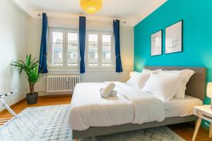 a bedroom with a large bed with blue walls at Le Havre des Cigognes - Grand T3 à Strasbourg in Strasbourg