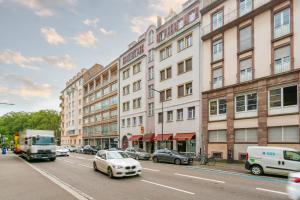 a busy city street with cars and buildings at Le Havre des Cigognes - Grand T3 à Strasbourg in Strasbourg +5 photos