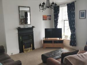 a living room with a television and a fireplace at Estuary View Bank House Stunning apartment in Millom