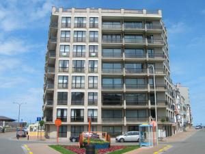 een hoog gebouw met auto's ervoor geparkeerd bij EnJOY Zee en uitzicht op Hinterland Westende in Middelkerke