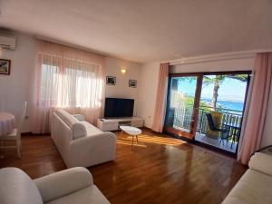 a living room with white furniture and a balcony at Apartments Villa Eden in Preko +14 photos
