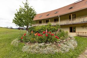 a garden in front of a house with flowers at Natura Planinca in Kalobje +24 photos